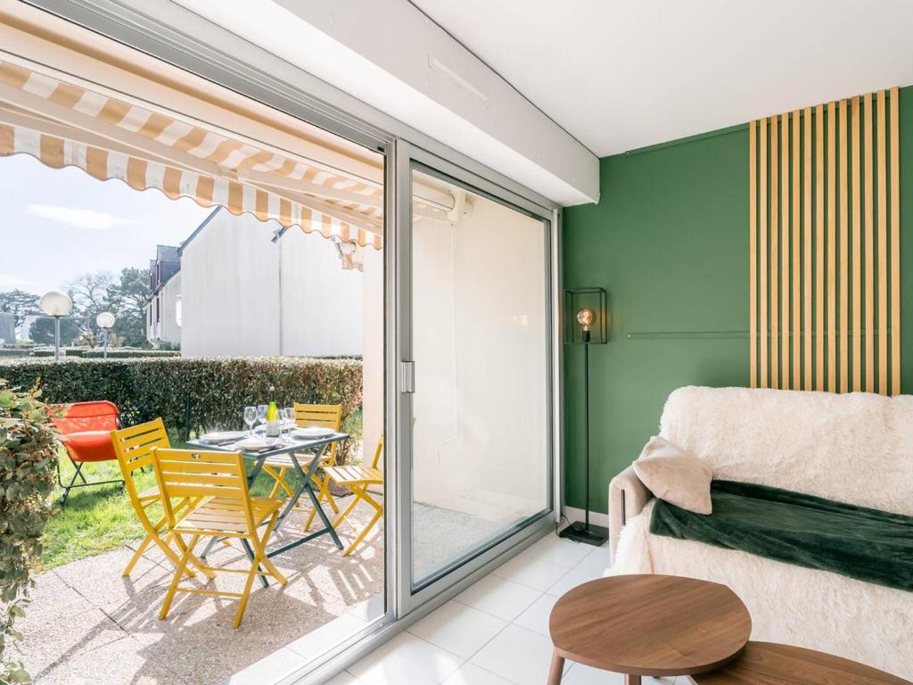 Cette chambre dispose d'une terrasse avec une table et des chaises. dans l'établissement Carnac : Appartement 2 pièces avec parking, proche plage - FR-1-477-256, à Carnac