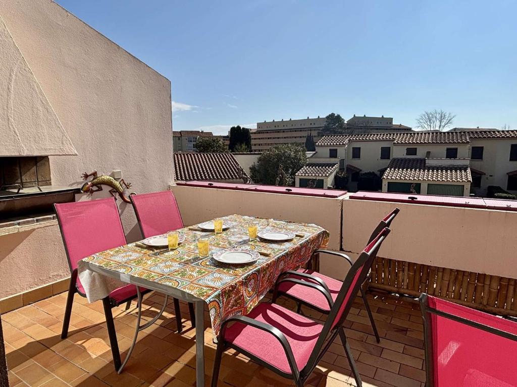 une table sur un balcon avec des chaises roses dans l'établissement Argelès - Appartement 2 pièces pour 4 personnes, piscine - FR-1-225-828, à Argelès-sur-Mer