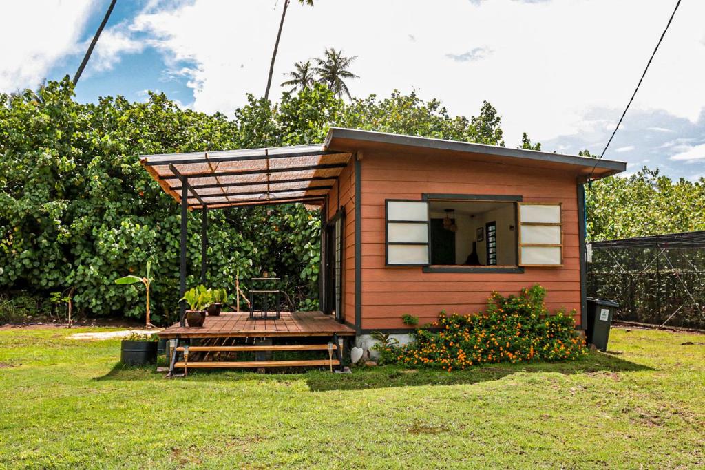 uma pequena casa com um alpendre e um deque em Tahaa Cosy Home em Tautu