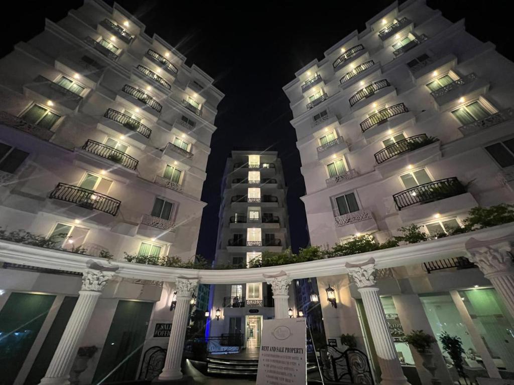 two large white buildings at night with lights at City Garden Olympus Condo By Vacation Vibes in Pattaya South