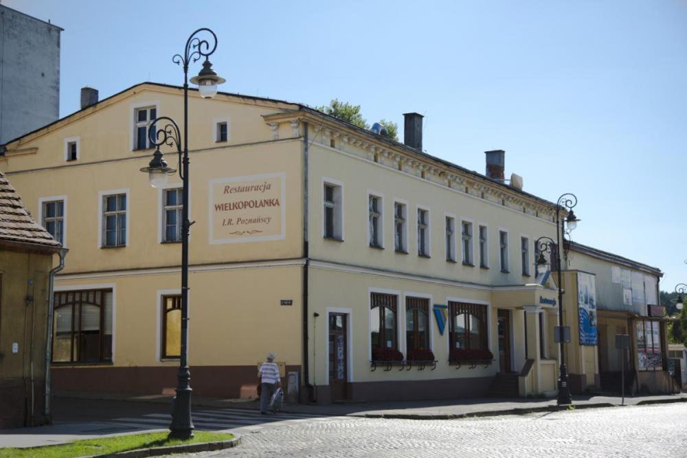 a man is standing in front of a building at Wielkopolanka Pokoje gościnne i Restauracja in Chodzież