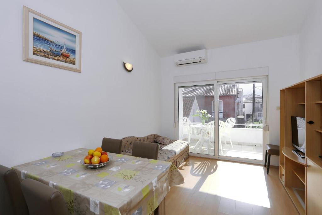 una sala de estar con una mesa con un bol de fruta. en Apartments Olga, en Božava