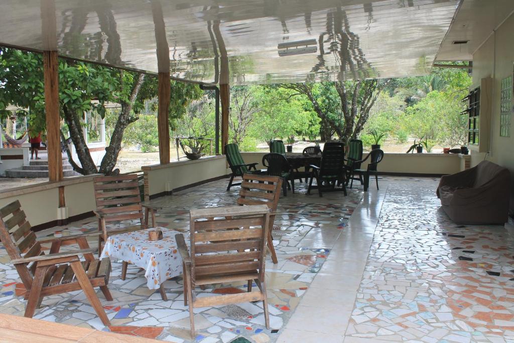 um restaurante com mesas e cadeiras de madeira e uma sala com janelas em Sonja's Guesthouse em Zanderij