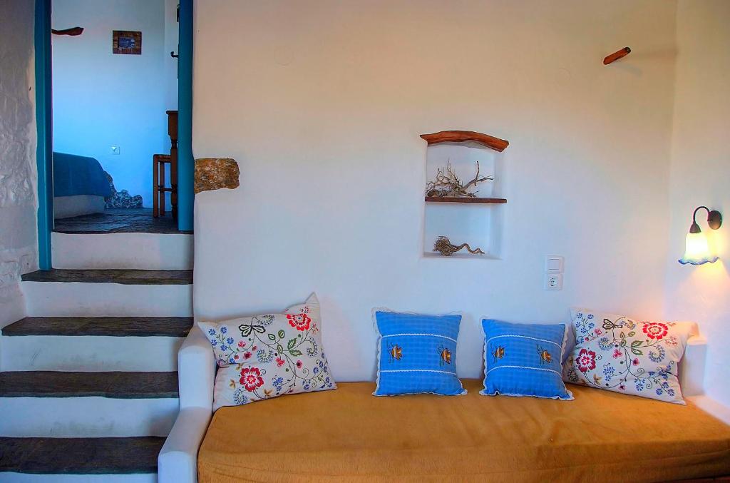 a room with a couch with blue pillows at Pano Gitonia in Aegiali