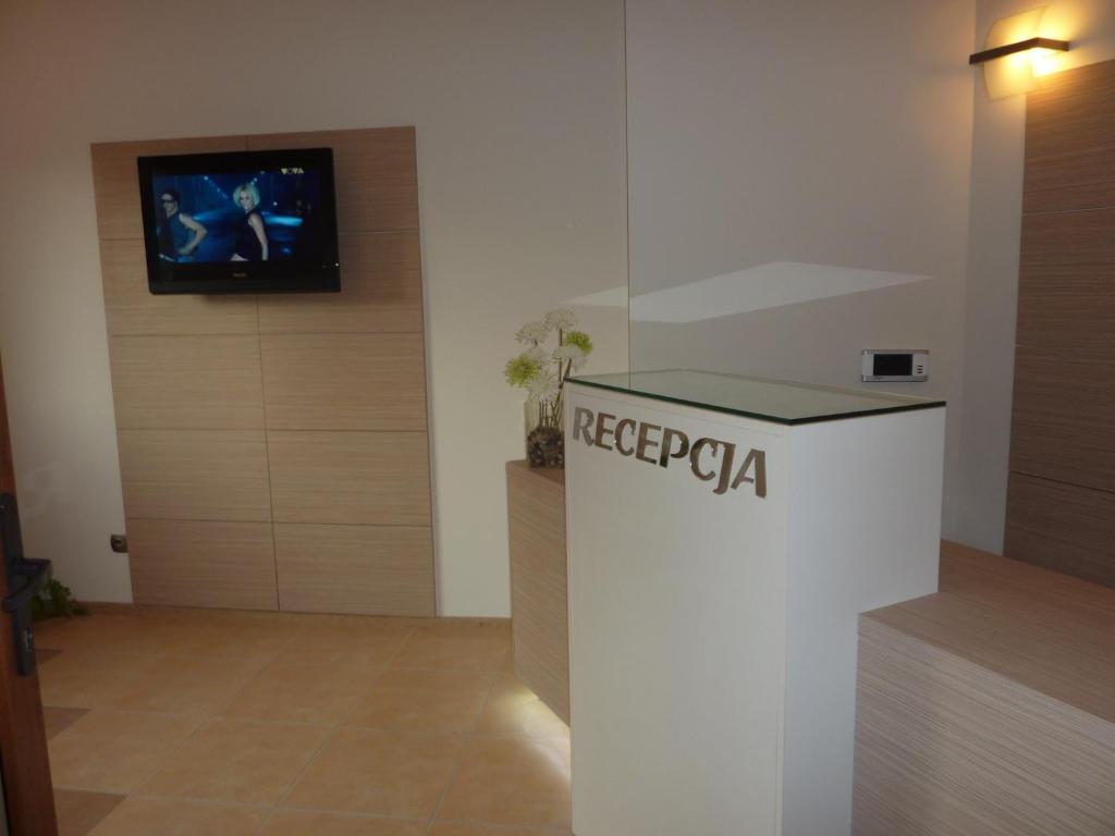 a room with a reception desk with a tv on a wall at Zajazd Arka in Łódź