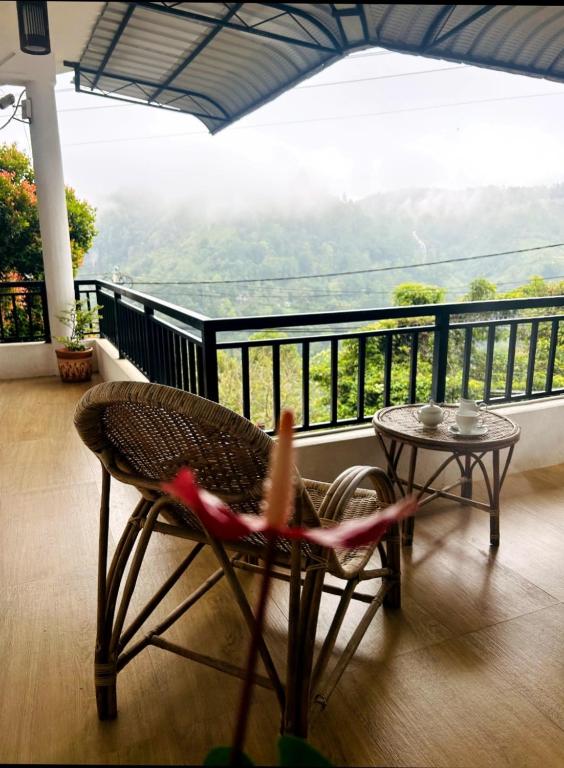 a chair and a table on a balcony with a view at Ella viewpoint sunnyview in Ella