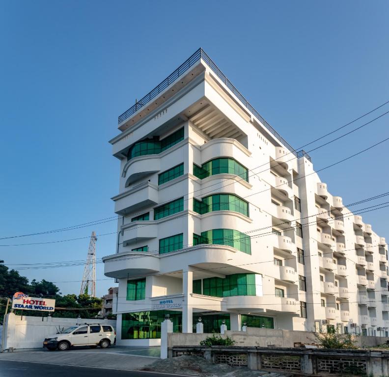 根尼亚古马里Hotel Staar World的一栋建筑前停着一辆车