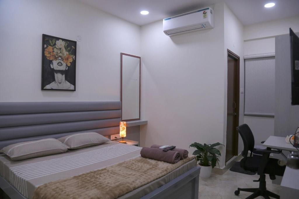 a bedroom with a bed and a desk and a chair at Yendluri's- QueenBed Room-25 Kondapur, Gachibowli in Lingampalli