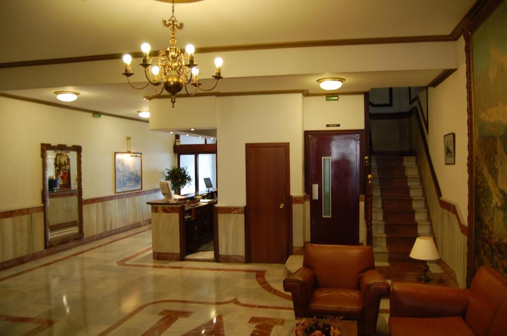 a lobby with a staircase and a chandelier at Hotel Marina Victoria in Algeciras