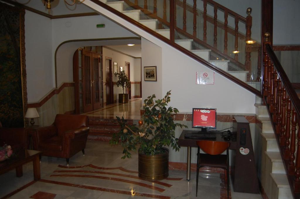 a lobby with a staircase with a computer on a desk at Hotel Marina Victoria in Algeciras