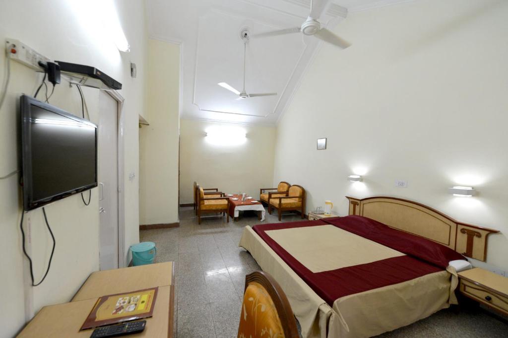Un dormitorio con una cama y un televisor de pantalla plana. en Ethnic India Tourist Resort, en Rāi