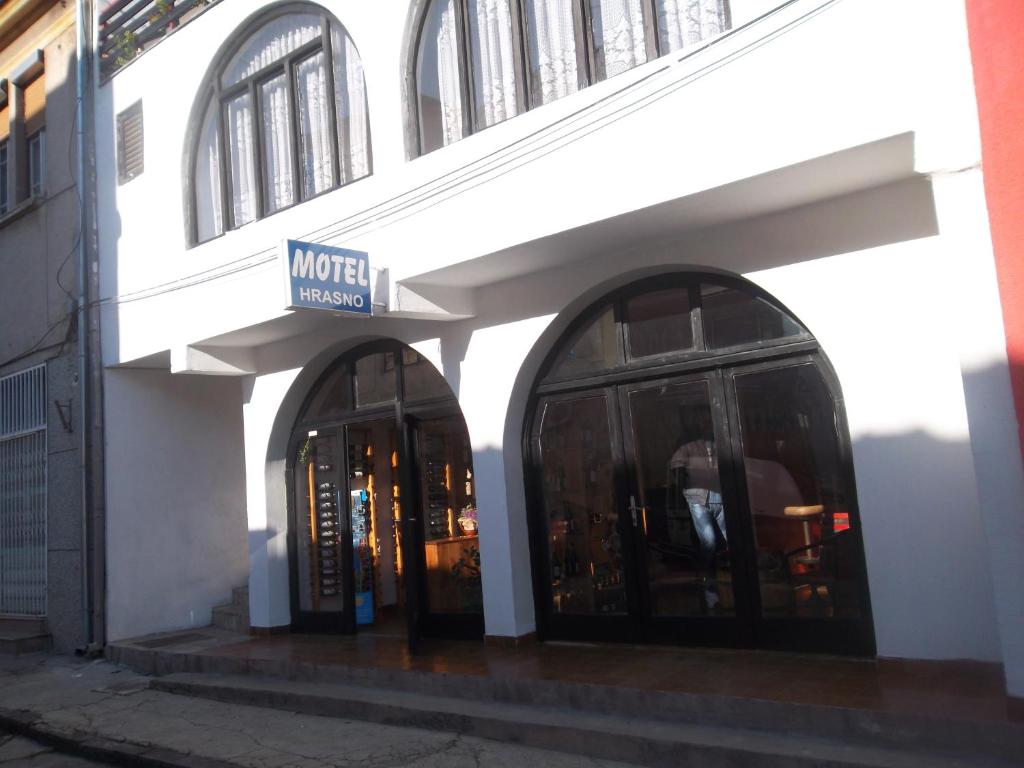 a building with two arched windows and a sign on it at Motel Hrasno in Čapljina