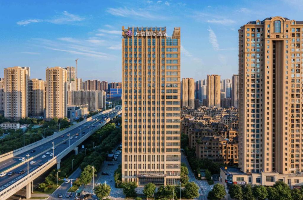 Xinzhuzhenにある西安奥体浐灞会展中心万信国际酒店の高速道路付きの都市の高層ビル