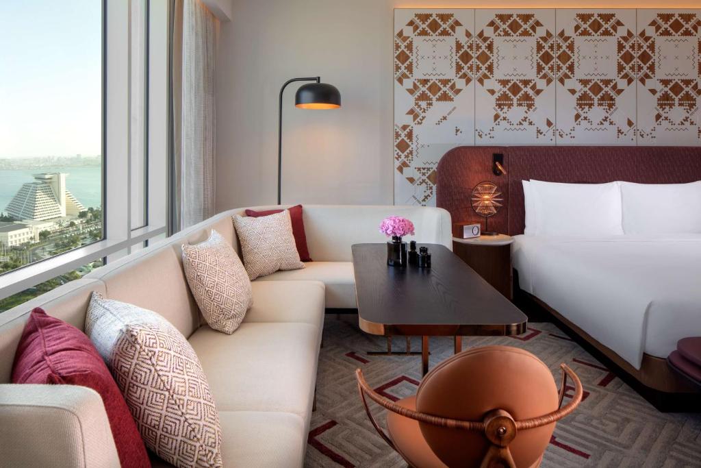 salon z kanapą, łóżkiem i stołem w obiekcie Andaz Doha, by Hyatt w mieście Doha