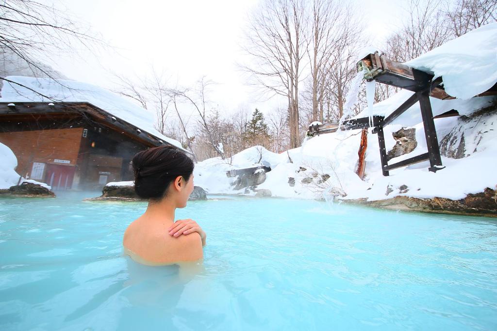 a young boy in a hot tub in the snow at Awanoyu in Matsumoto