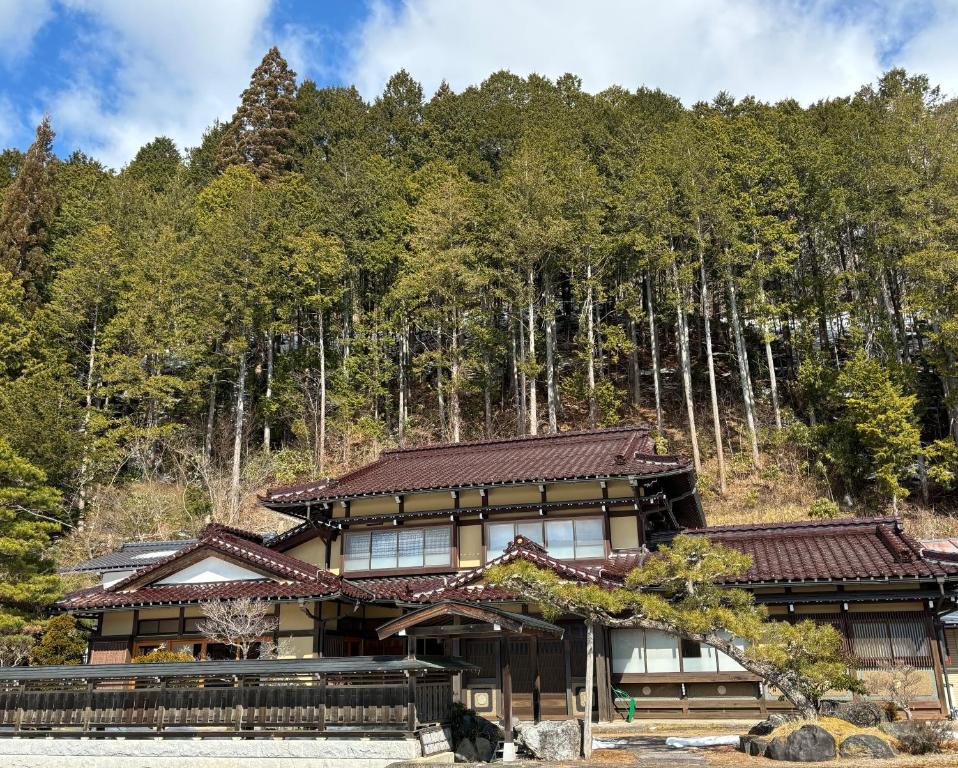 un edificio di fronte a un bosco di alberi di sunny sidde a Takayama