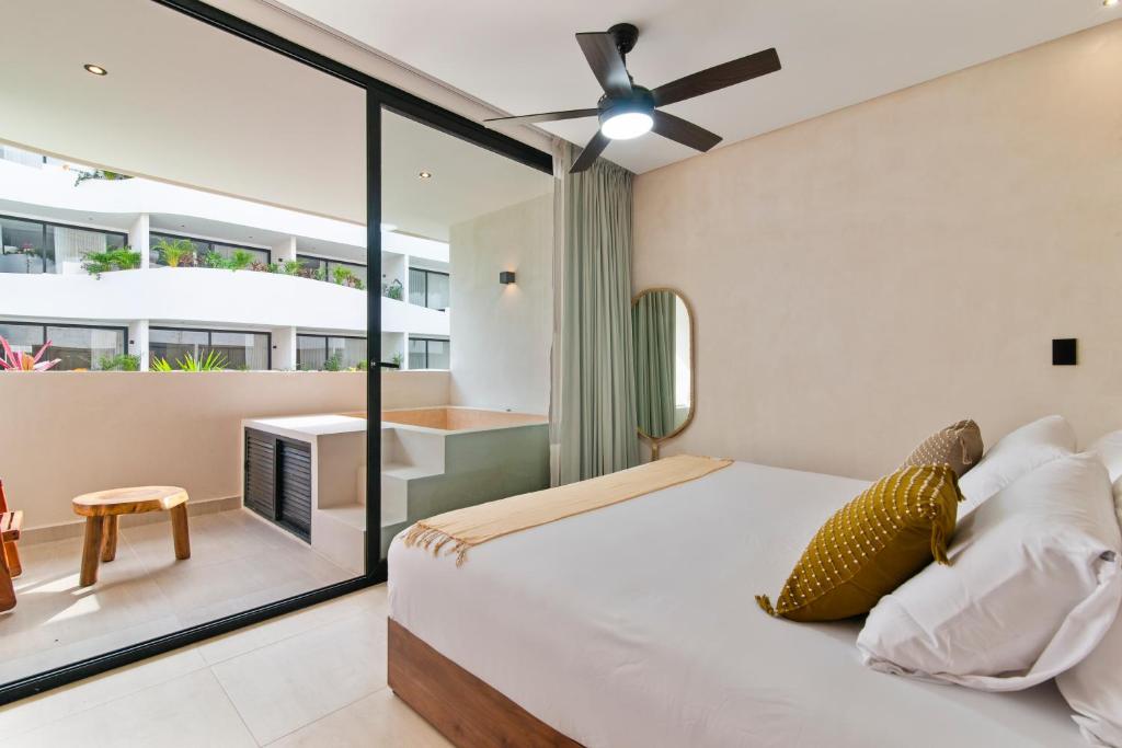 una camera con letto e balcone di Guest INN Home - Elements Suites a Tulum