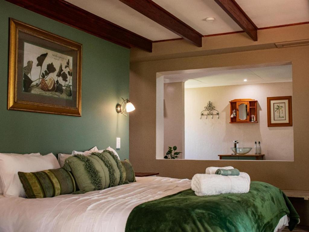 a bedroom with a large bed with green walls at Tranquility Town Stays in Winterton