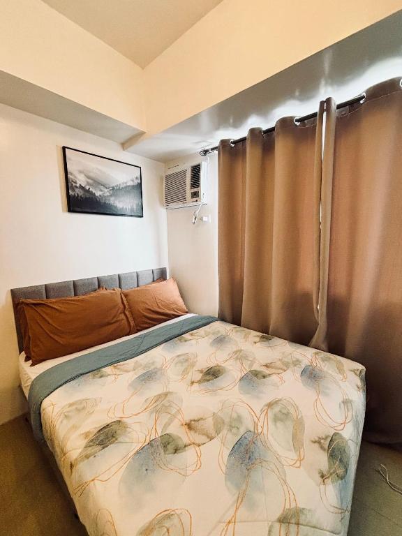 Dormitorio pequeño con cama con cortina en Your Minimalist Cozy Haven, en Iloilo City