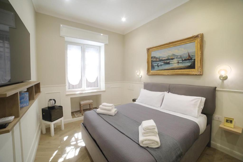 Un dormitorio con una cama con toallas blancas. en Vico Croce Suite, Spaccanapoli, en Nápoles