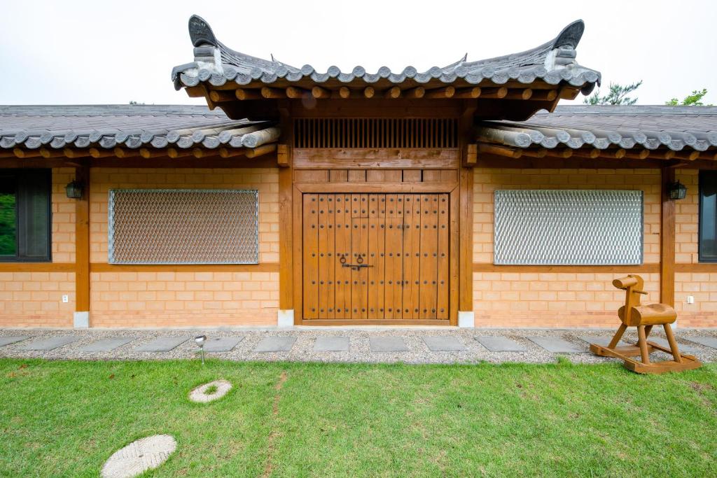 a house with a gate and a statue in front of it at Yangyang Cheongjong Healing Forest Pension in Chan'gyo-ri