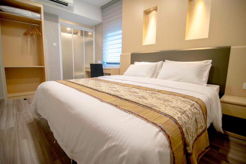 una camera da letto con un grande letto con lenzuola bianche di 33 Boutique Hotel Bandar Sunway a Petaling Jaya