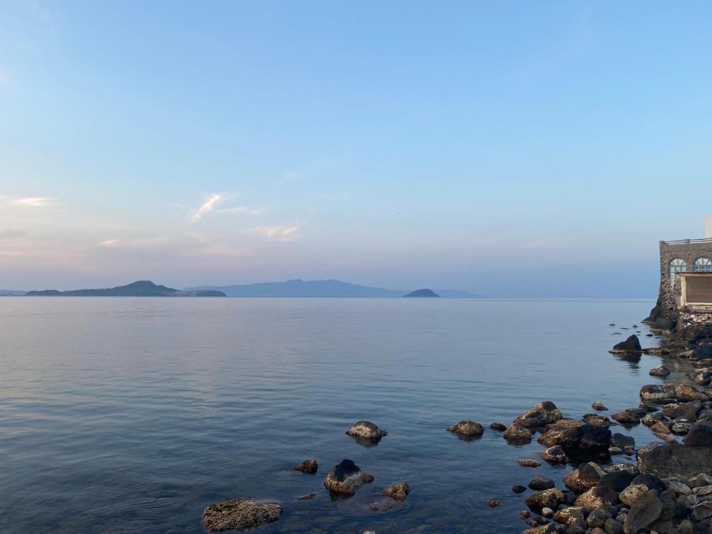 a view of a body of water with rocks at Home on the beach Vastadi in Mandrákion