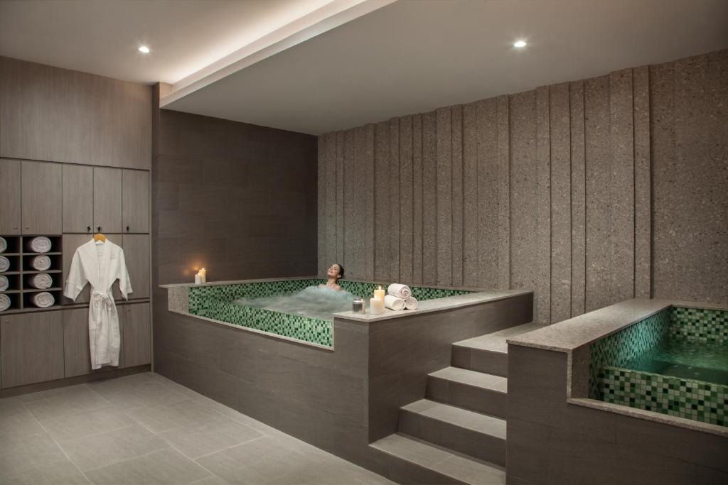 a woman in a bath tub in a bathroom at Fraser Place Setiabudi Jakarta in Jakarta