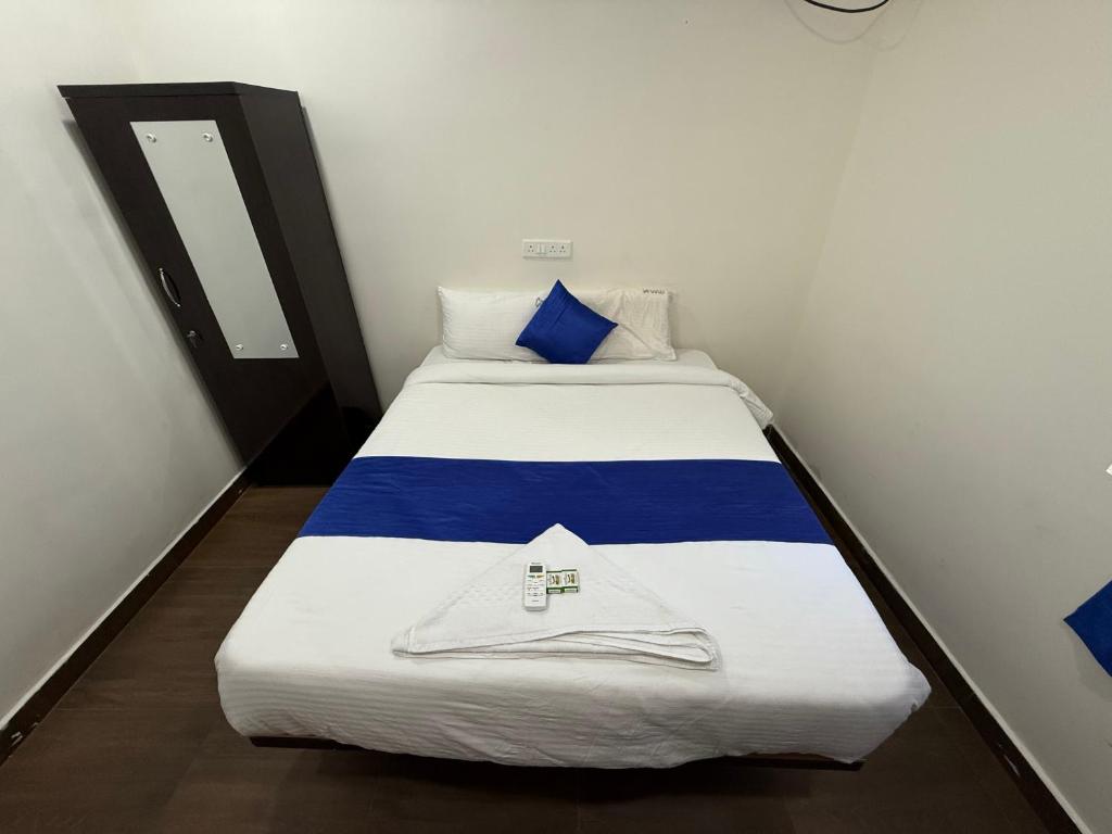 a bed in a room with a blue and white blanket at COCO NET Hotel in Ibrāhīmpatan