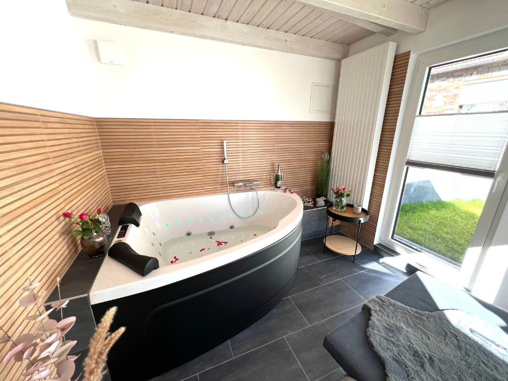 Habitación con baño grande con bañera grande. en Privat Sauna Whirlpool Blockhaus- Balance Apartments by M&A, en Witzenhausen