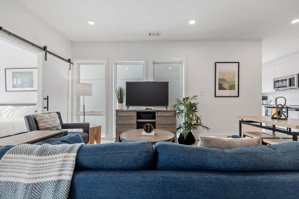 a living room with a blue couch and a tv at NoMa Convenience 2-BR Near Metro Union Market in Washington, D.C.