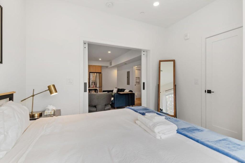 a bedroom with a large white bed and a mirror at NoMa Convenience 2-BR Near Metro Union Market in Washington, D.C.