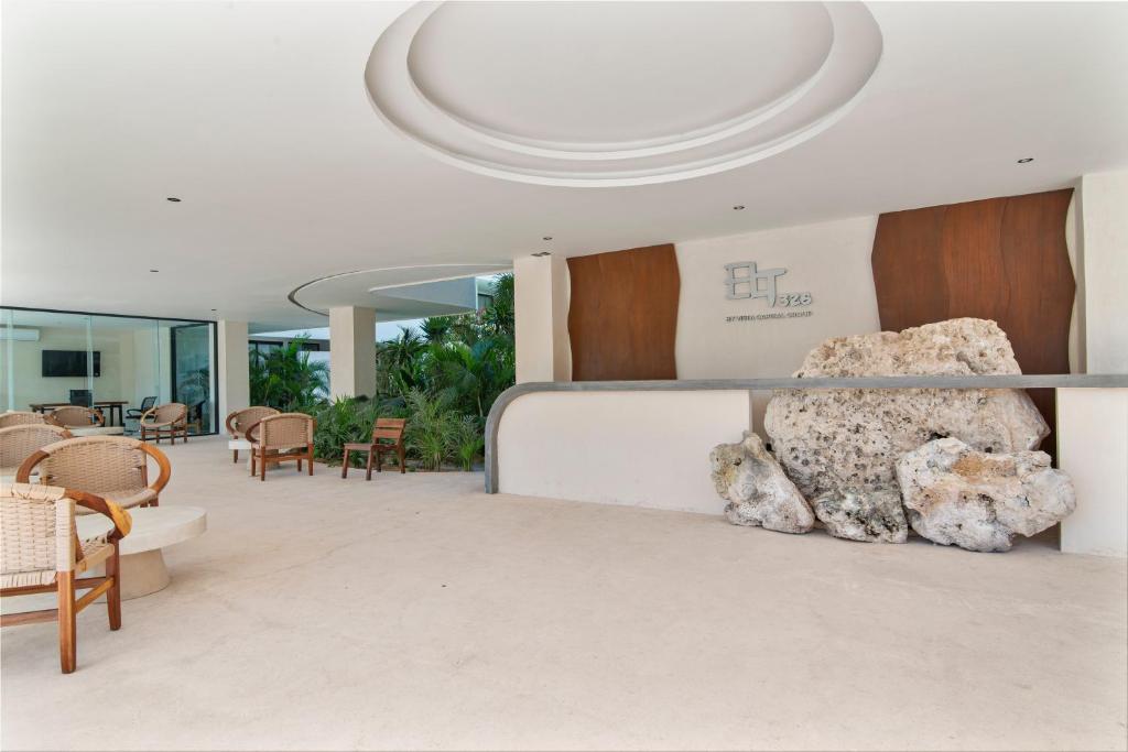 una hall con una grande roccia sul muro di Guest INN Home - Elements Suites a Tulum