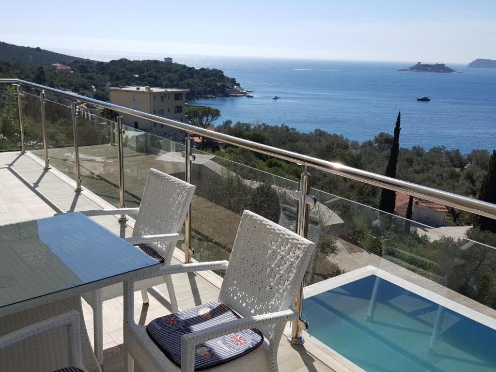 a balcony with a table and chairs and the ocean at Apartments Marovic in Herceg-Novi