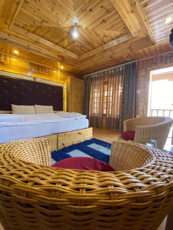 a bedroom with a bed and chairs in a room at Cozinn A104 in Leh