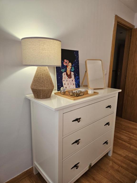 a dresser with a mirror and a lamp on it at Ezcaray Pet Friendly, piscina y parking in Zorraquín