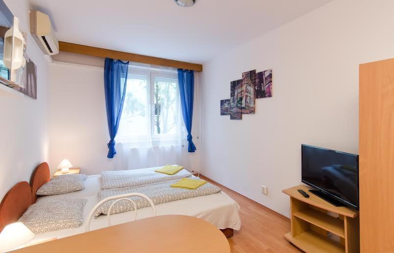 a small bedroom with a bed and a television at Young Center in Budapest