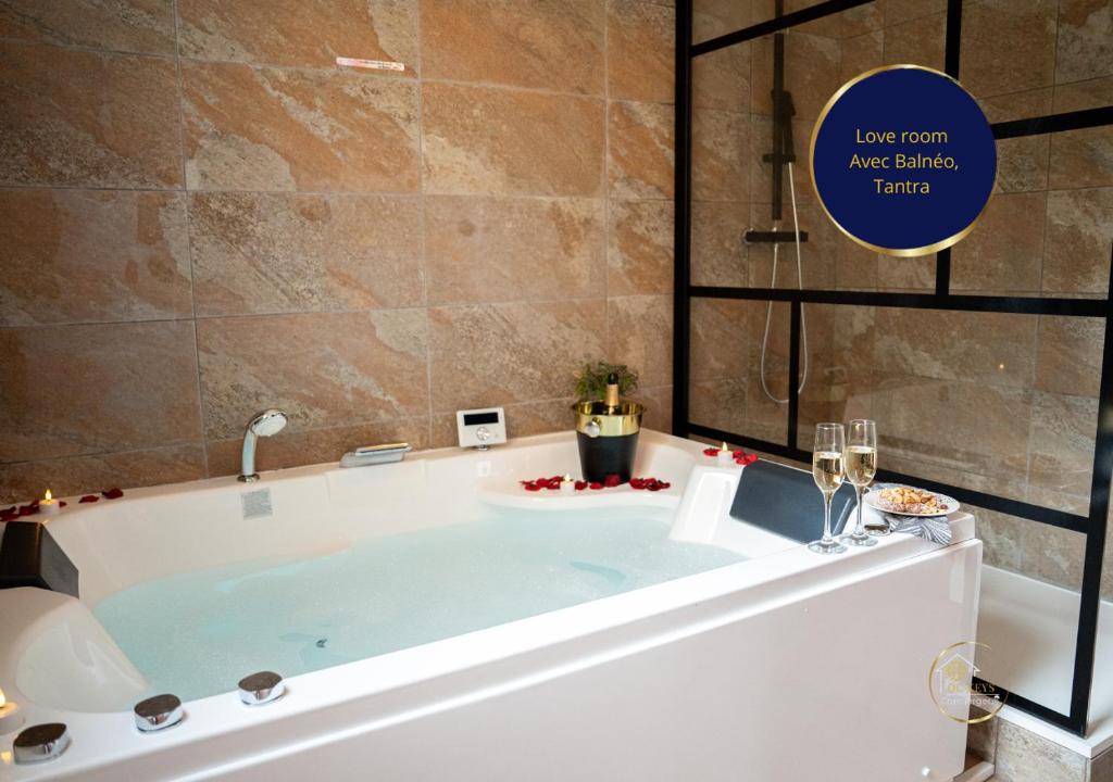 a bath tub in a bathroom with wine glasses at L'Ecrin d'Albi - Love Room - 1 chambre in Albi