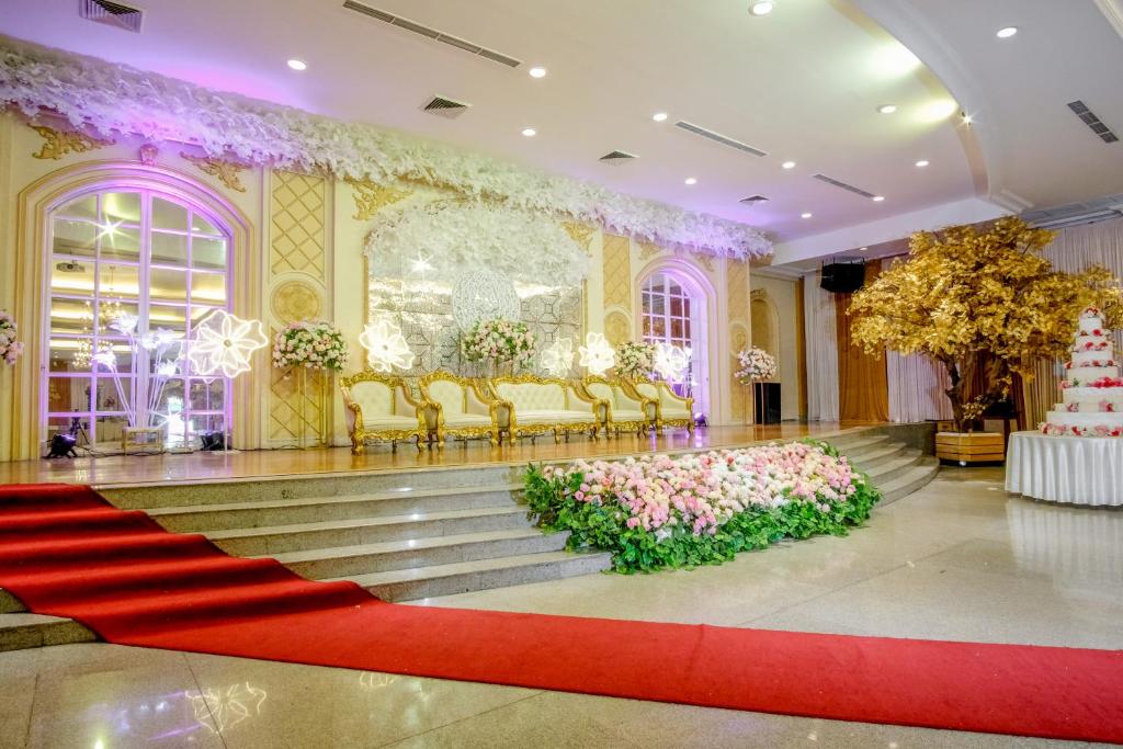 una camera con tappeto rosso, sedie dorate e tappeto rosso di Istana Nelayan Hotel & Convention Powered by Archipelago a Kerontjong Satu