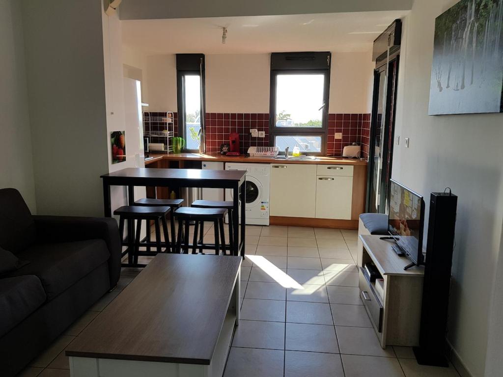 a living room with a couch and a table at APPARTEMENT 100m DE LA PLAGE ST PIERRE in Saint-Pierre