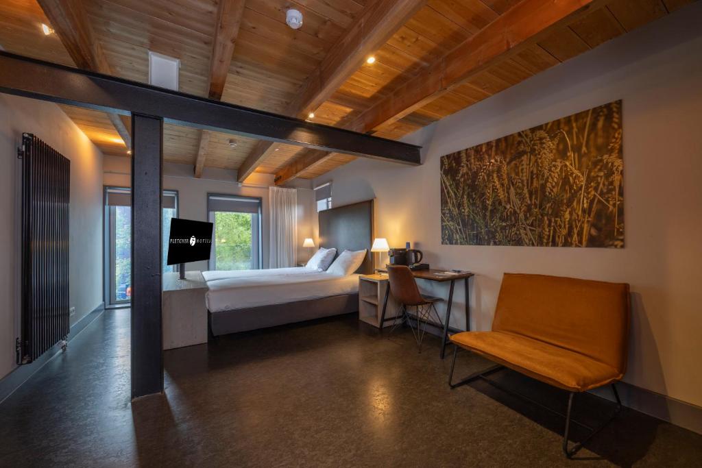 een slaapkamer met een bed, een tafel en een stoel bij Fletcher Hotel-Restaurant Kasteel Coevorden in Coevorden