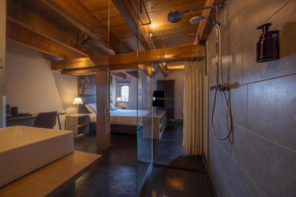 een badkamer met een douche en een slaapkamer met een bed bij Fletcher Hotel-Restaurant Kasteel Coevorden in Coevorden