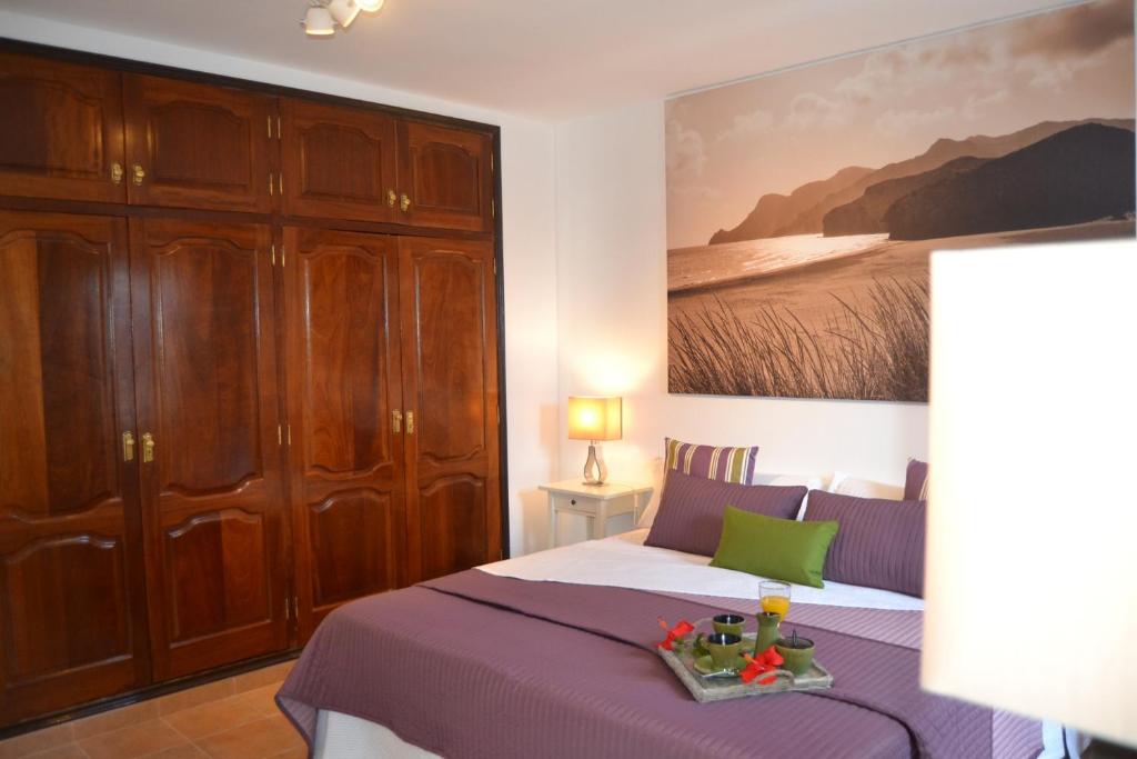 1 dormitorio con 1 cama y una pintura en la pared en Villa Jupe, en Tías