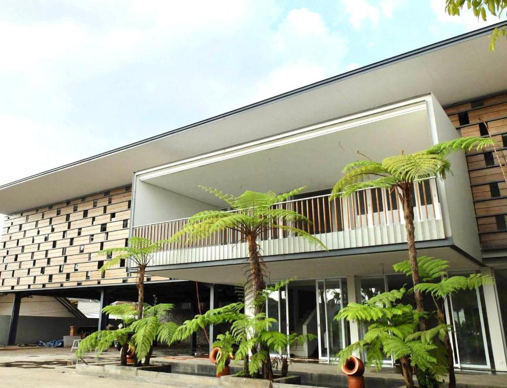 a building with palm trees in front of it at Proven Living in Bandung