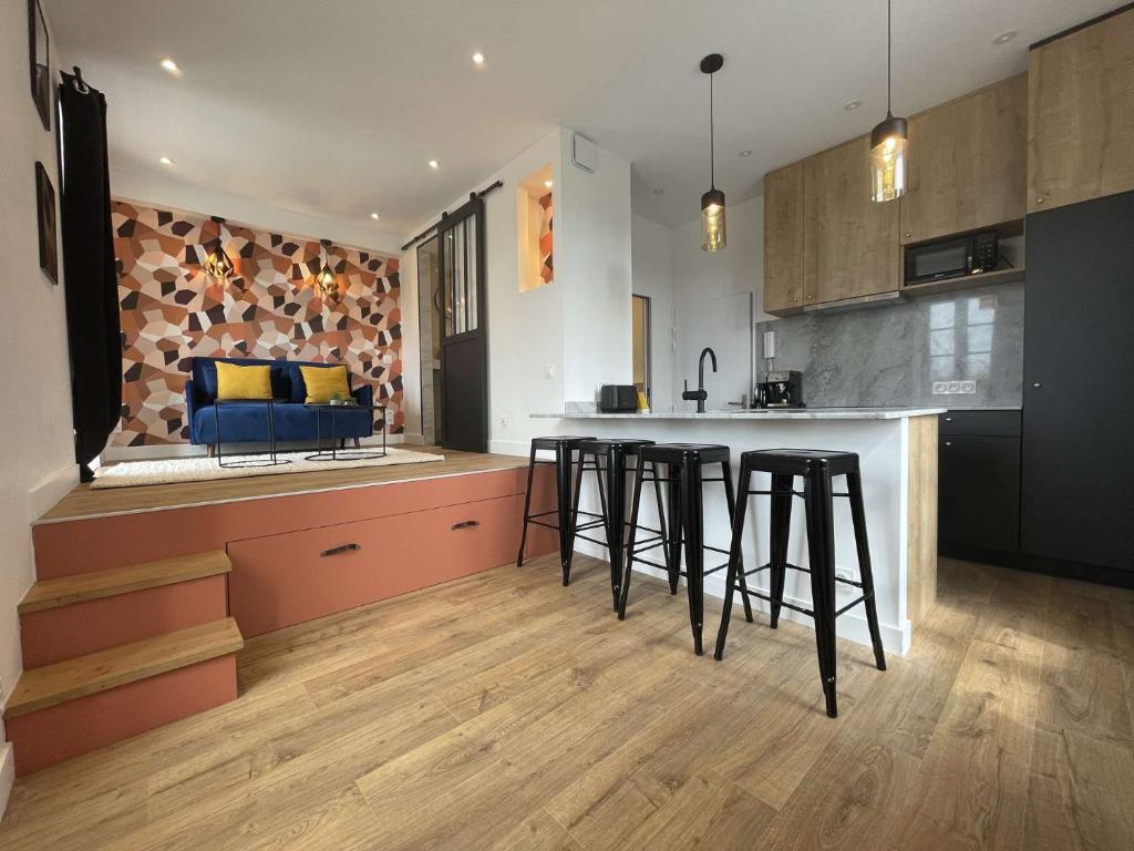 - une cuisine avec un bar et des tabourets dans la chambre dans l'établissement Appt Studio LA ROCHELLE - LR180-01B, à La Rochelle