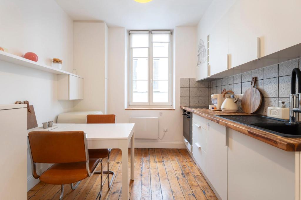 une cuisine avec une table blanche et des chaises dans l'établissement Studio Secundo, à Metz