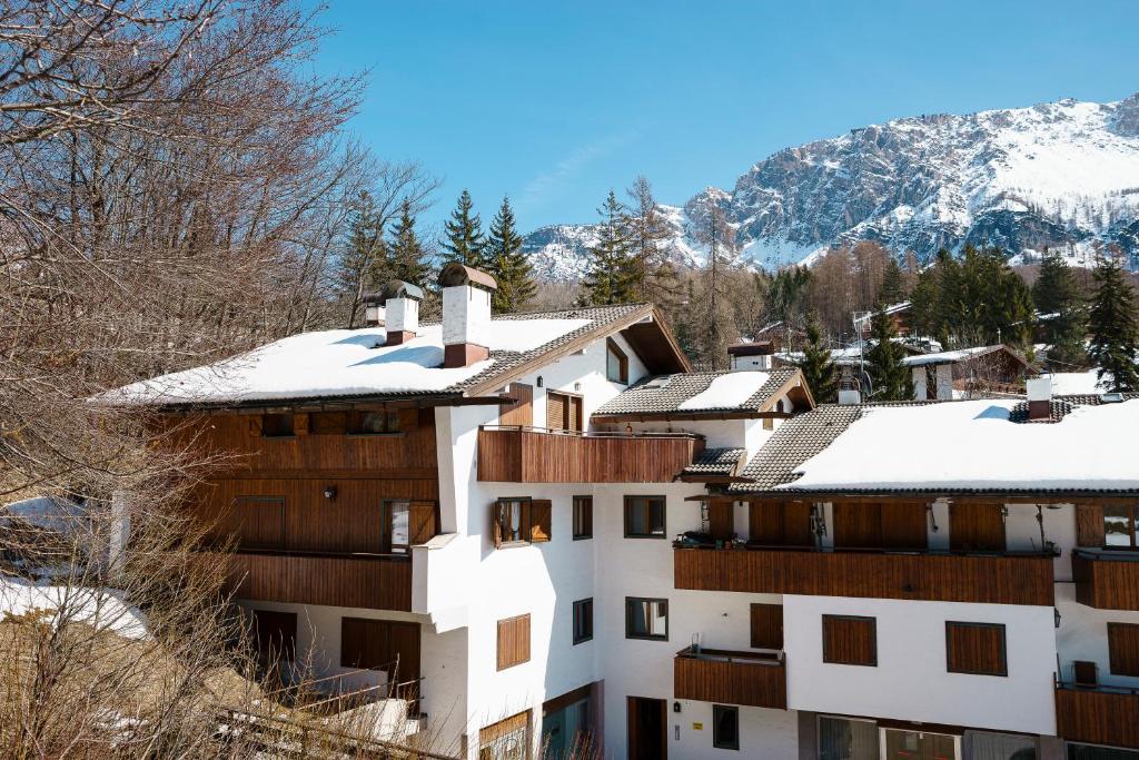 Un bâtiment blanc avec de la neige au-dessus dans l'établissement Villa Franchetti - Stayincortina, à Cortina dʼAmpezzo