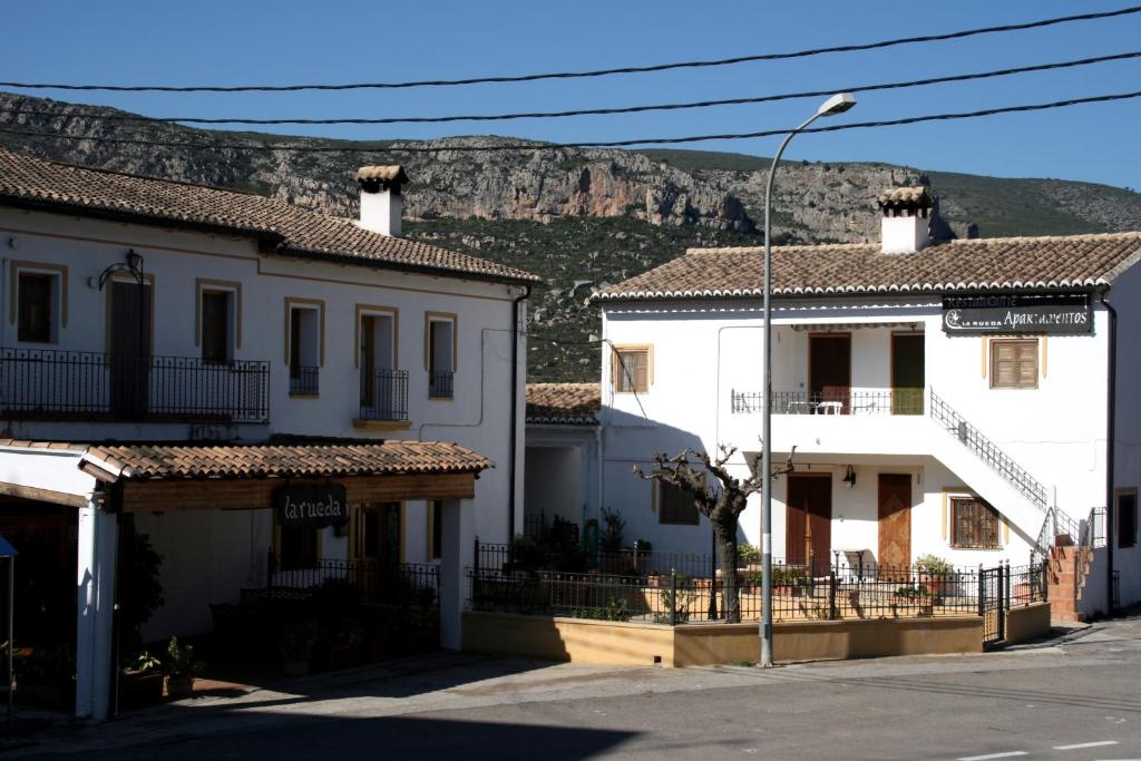 un grupo de edificios con una montaña en el fondo en La Rueda Apartamentos Rurales en Chulilla