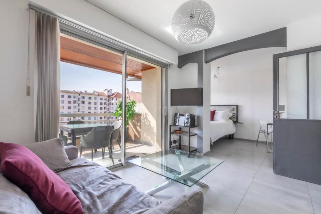 un salon avec un canapé et une table en verre dans l'établissement Résidence L'Ecrin - Appartement en Centre ville, à Annecy