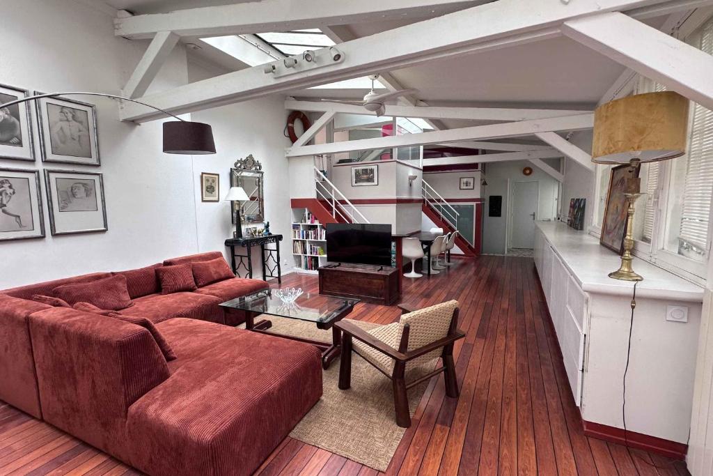 un salon avec un canapé et une table dans l'établissement Atypical Loft in the Heart of the Marais, à Paris